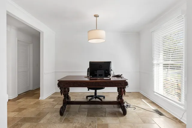 a view of a workspace with furniture and a window