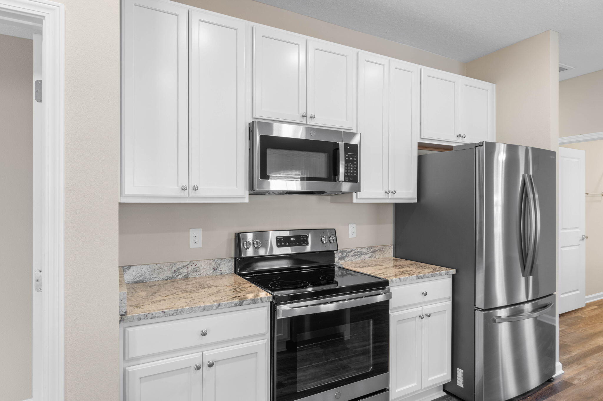 145 4th Avenue Crestview, FL 32539 - Photo 12 of 31 a kitchen with stainless steel appliances granite countertop white cabinets and a stove a refrigerator with white cabinets