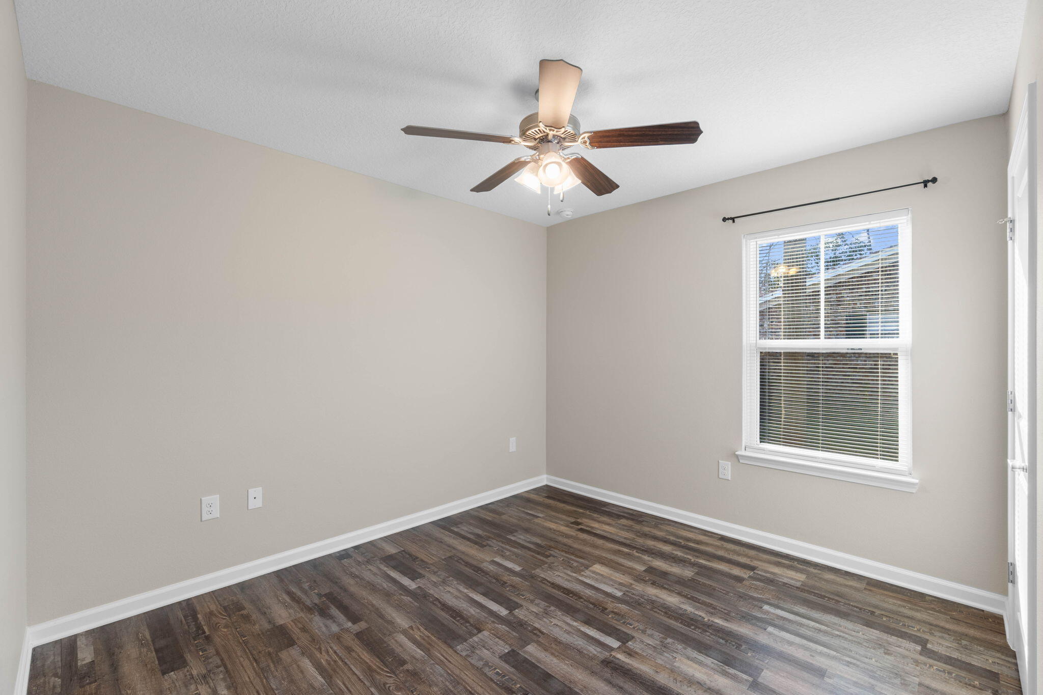 145 4th Avenue Crestview, FL 32539 - Photo 15 of 31 an empty room with wooden floor ceiling fan and windows