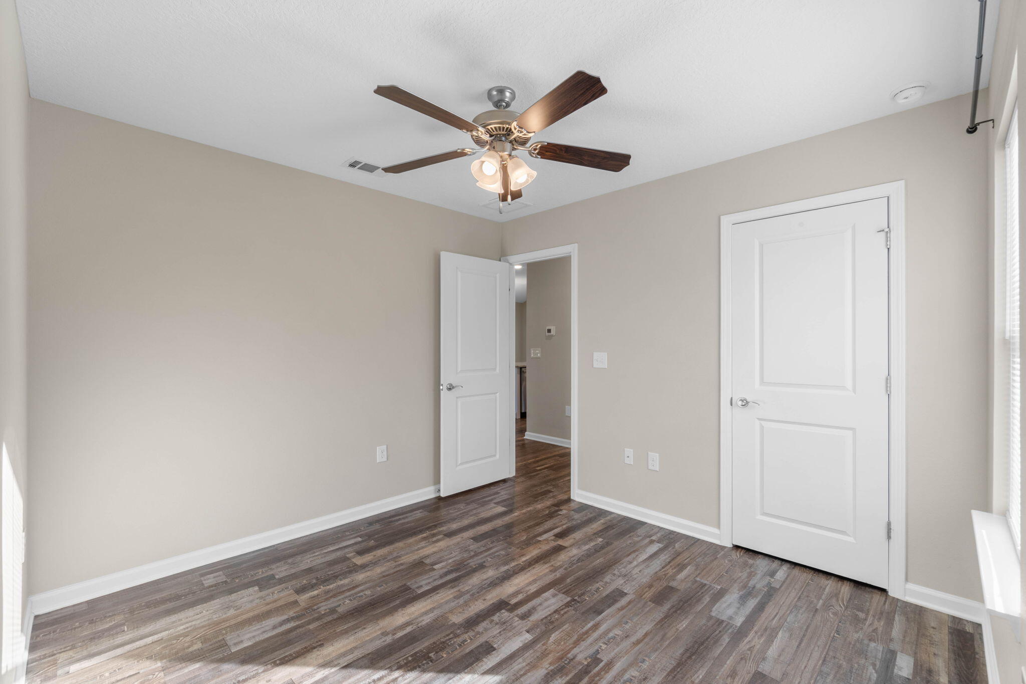 145 4th Avenue Crestview, FL 32539 - Photo 19 of 31 a view of an empty room with window and wooden floor