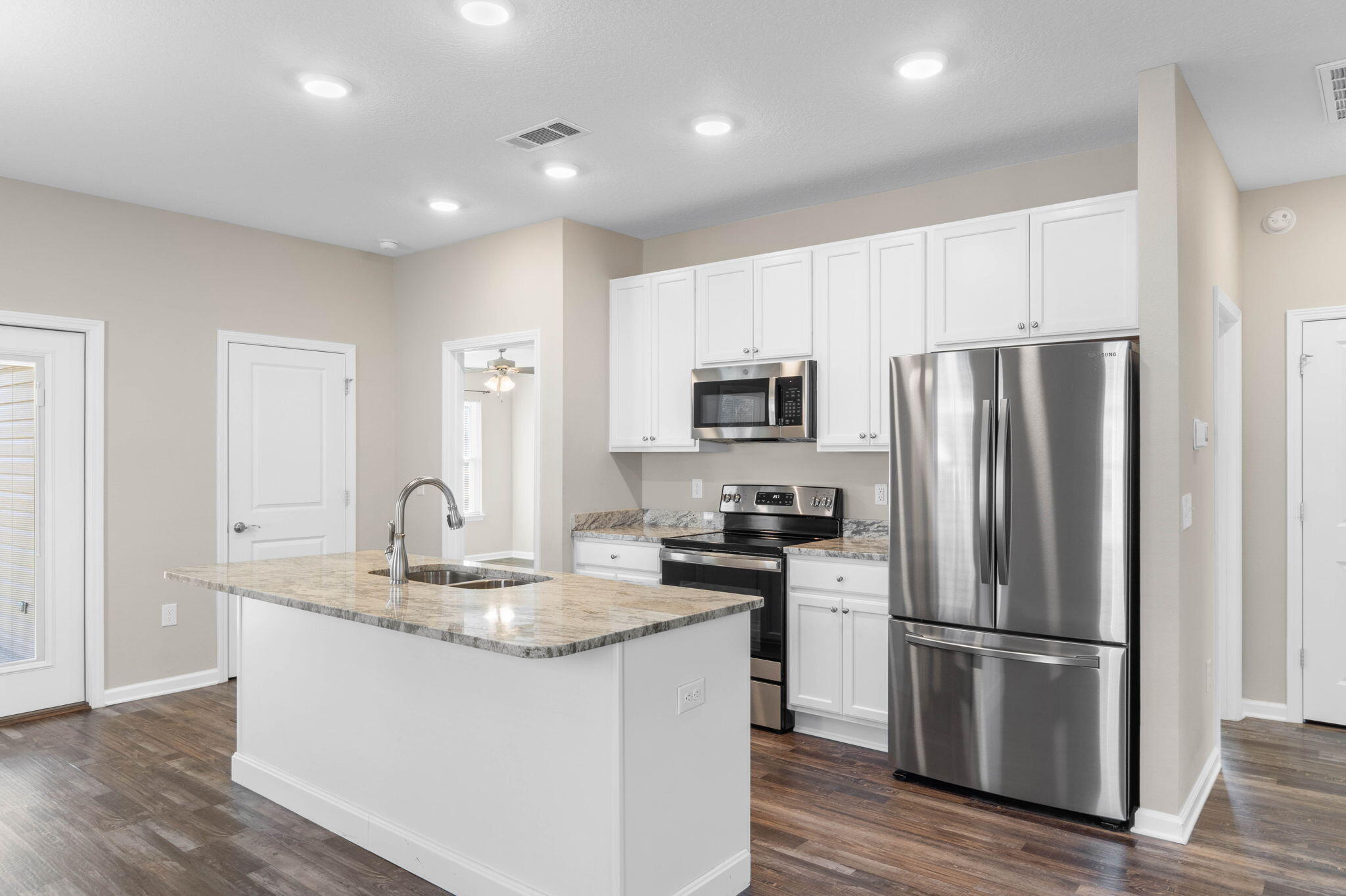 145 4th Avenue Crestview, FL 32539 - Photo 10 of 31 a kitchen with kitchen island granite countertop a refrigerator stove top oven and sink