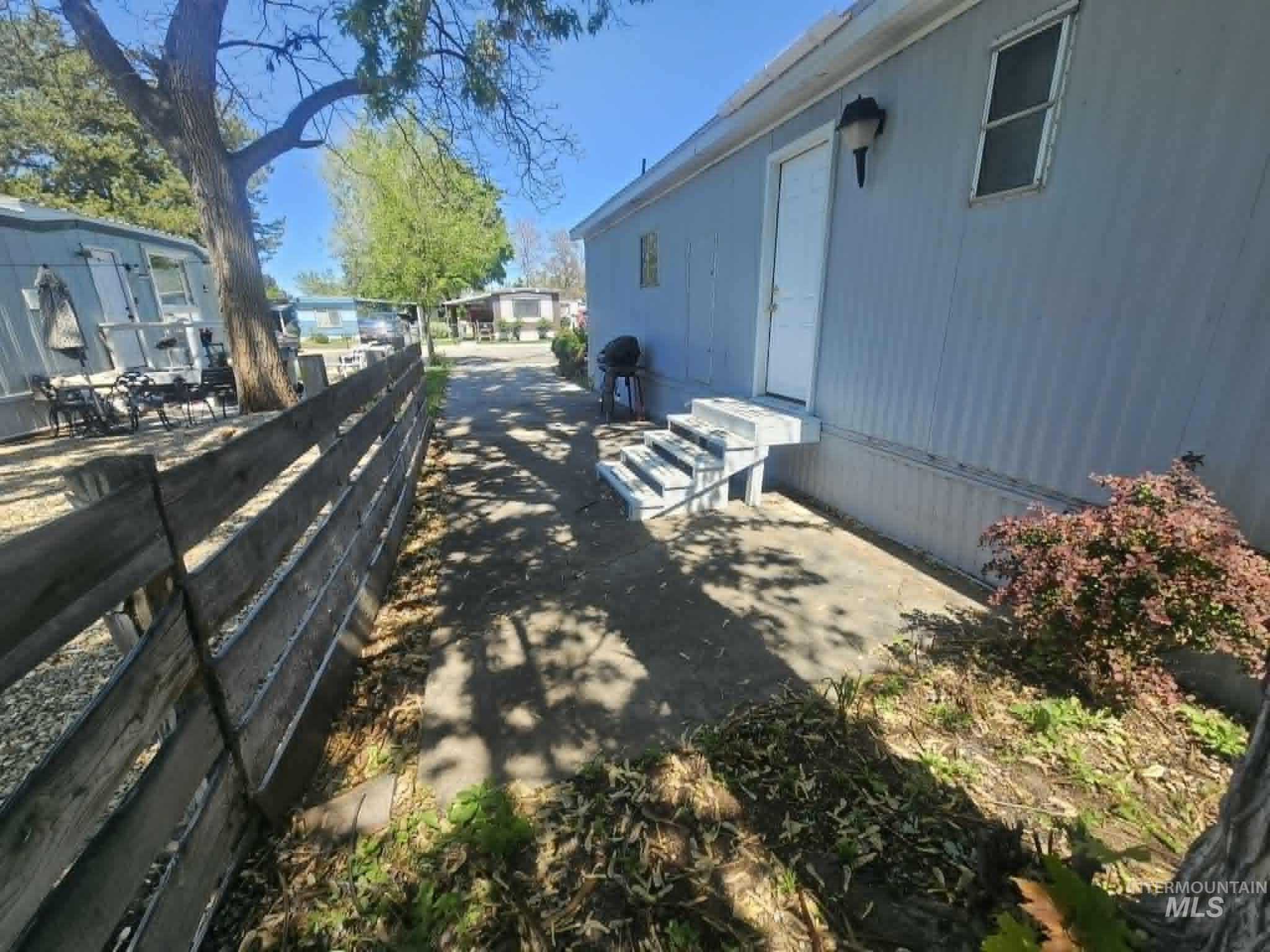 461 Greenleaf Street Boise, ID 83713 - Photo 15 of 19 Light blue exterior siding with white trim, featuring a side entry door and a tiered staircase