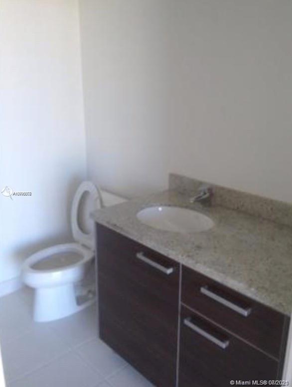 185 Southwest 7th Street, Unit 3403 Miami, FL 33130 - Photo 14 of 34 a bathroom with a granite countertop sink and a toilet