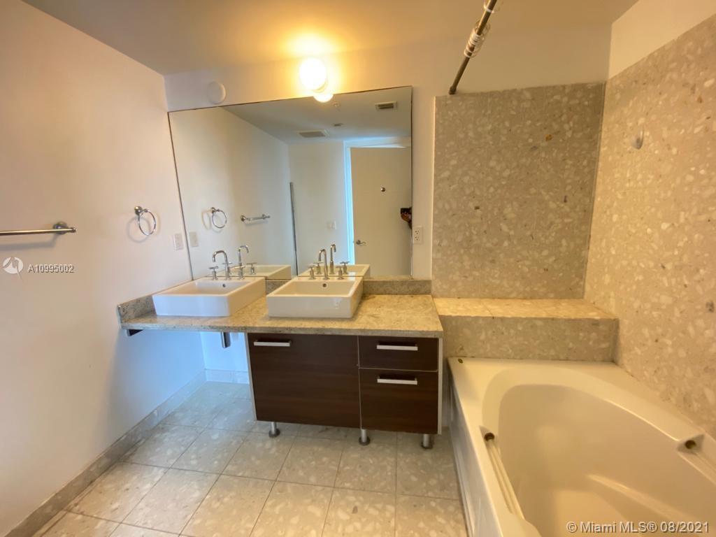 185 Southwest 7th Street, Unit 3403 Miami, FL 33130 - Photo 16 of 34 a bathroom with a tub sink and mirror
