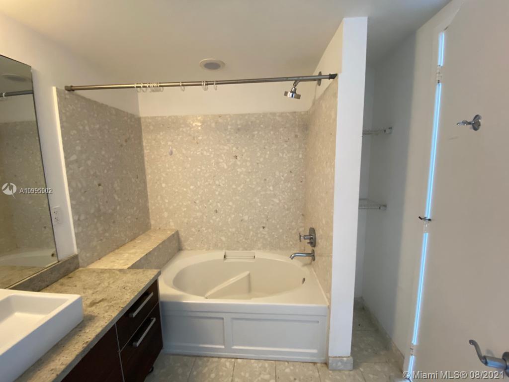 185 Southwest 7th Street, Unit 3403 Miami, FL 33130 - Photo 18 of 34 a bathroom with a granite countertop sink and a bathtub