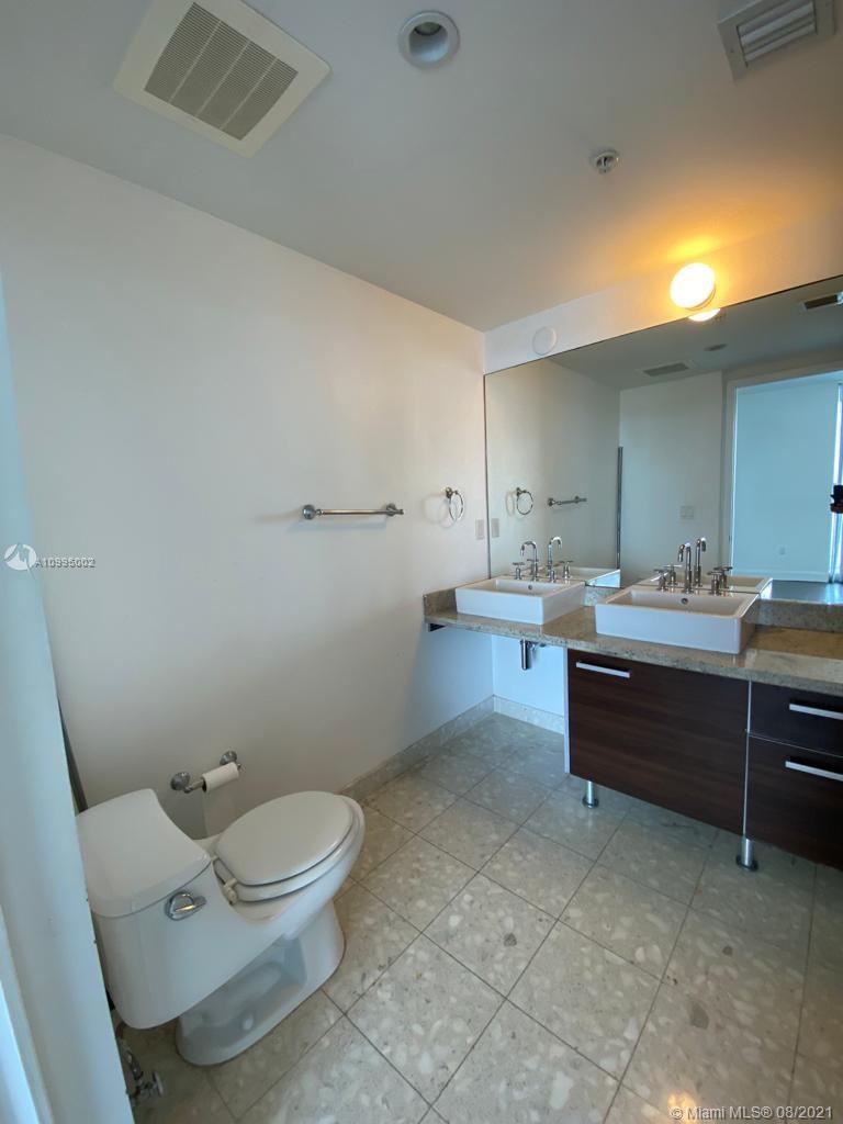 185 Southwest 7th Street, Unit 3403 Miami, FL 33130 - Photo 19 of 34 a bathroom with a sink a toilet and a mirror