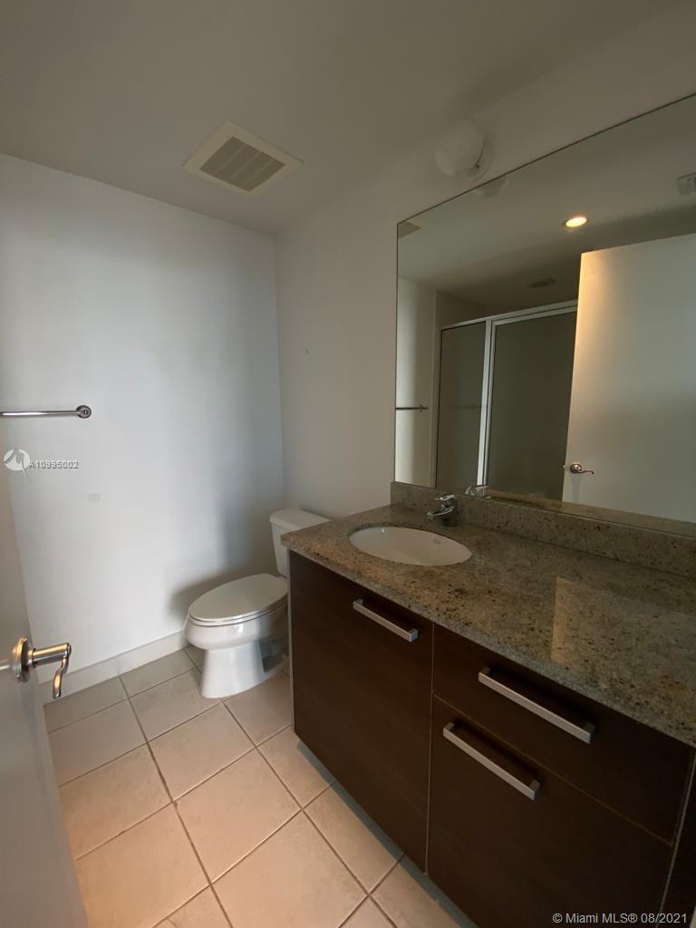 185 Southwest 7th Street, Unit 3403 Miami, FL 33130 - Photo 29 of 34 a bathroom with a granite countertop sink and a toilet