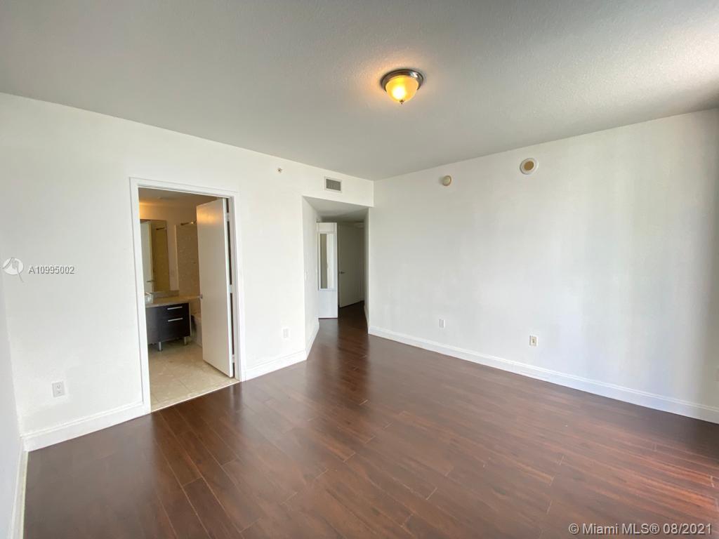 185 Southwest 7th Street, Unit 3403 Miami, FL 33130 - Photo 9 of 34 an empty room with wooden floor and closet
