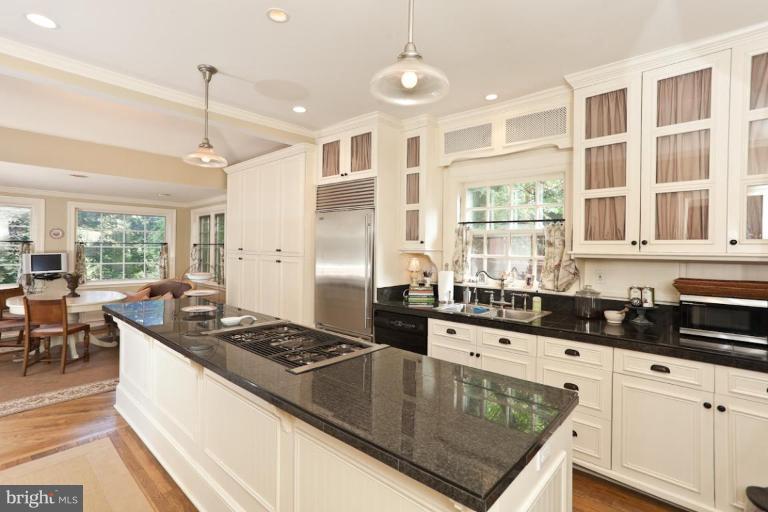 108 Longwood Road Baltimore, MD 21210 - Photo 23 of 28 a kitchen with granite countertop a stove a sink a refrigerator dining table and chairs