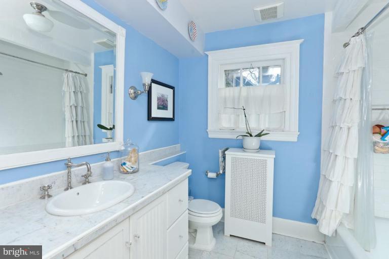 108 Longwood Road Baltimore, MD 21210 - Photo 7 of 28 a bathroom with a toilet a sink a mirror a window and vanity