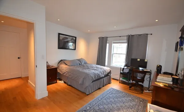a bedroom with a bed and wooden floor