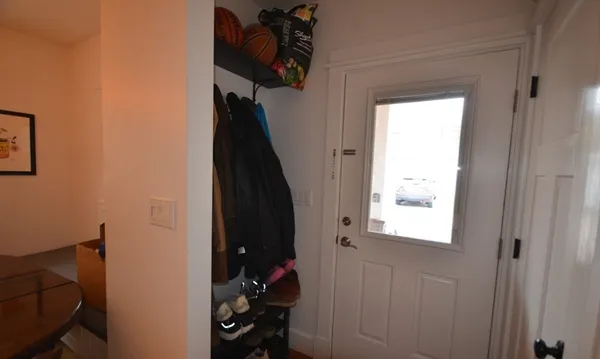 a view of a hallway with closet and a window
