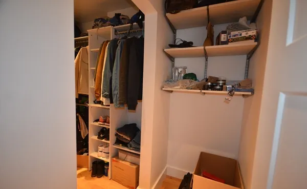 a view of walk in closet with clothes and shoes