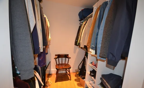 a view of walk in closet with clothes and shoes
