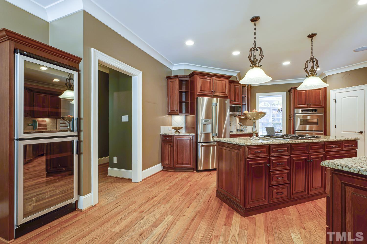 5201 Rathkeale Court Holly Springs, NC 27540 - Photo 16 of 46 a kitchen with stainless steel appliances granite countertop wooden floors and sink