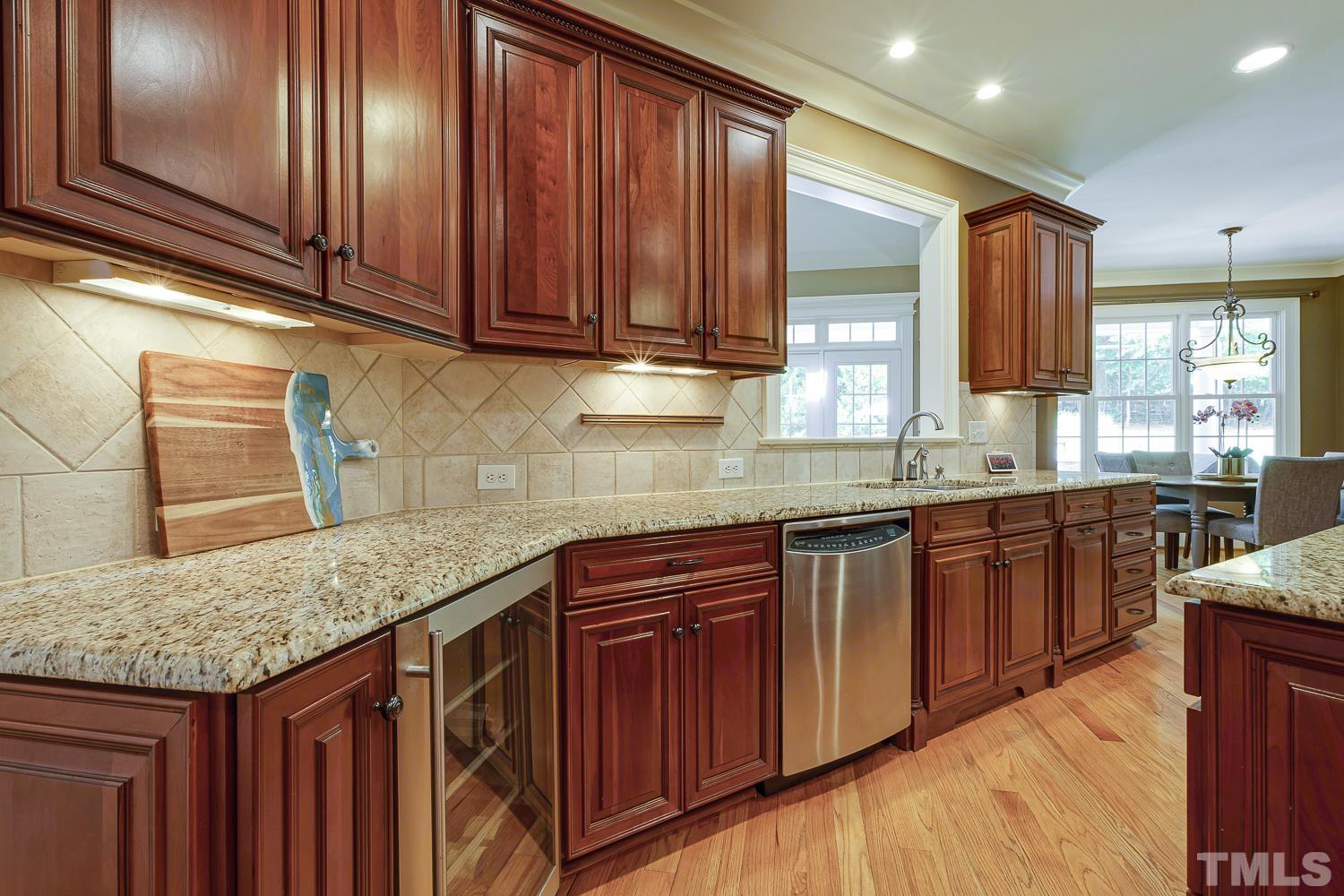 5201 Rathkeale Court Holly Springs, NC 27540 - Photo 19 of 46 a kitchen with stainless steel appliances granite countertop wooden cabinets a sink and dishwasher