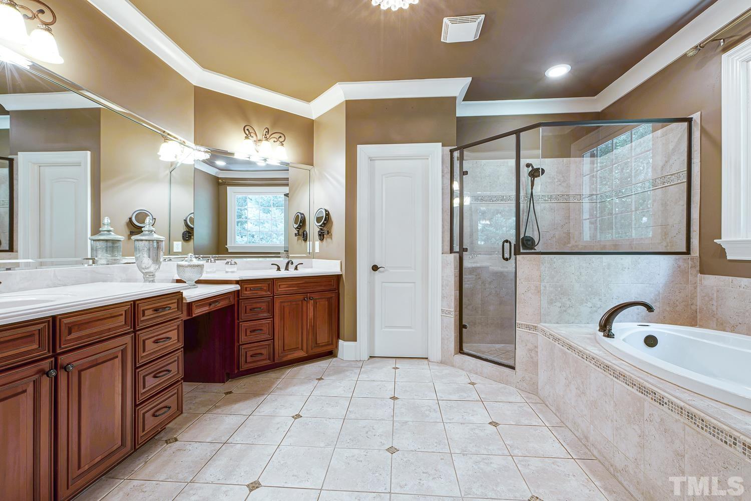 5201 Rathkeale Court Holly Springs, NC 27540 - Photo 21 of 46 a large bathroom with a tub a sink shower and mirror
