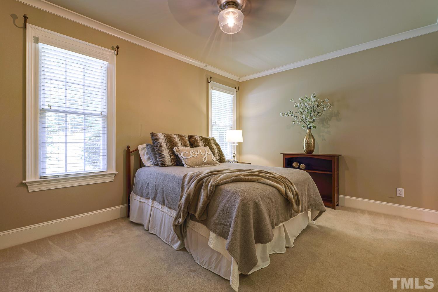 5201 Rathkeale Court Holly Springs, NC 27540 - Photo 22 of 46 a spacious bedroom with a bed and a window