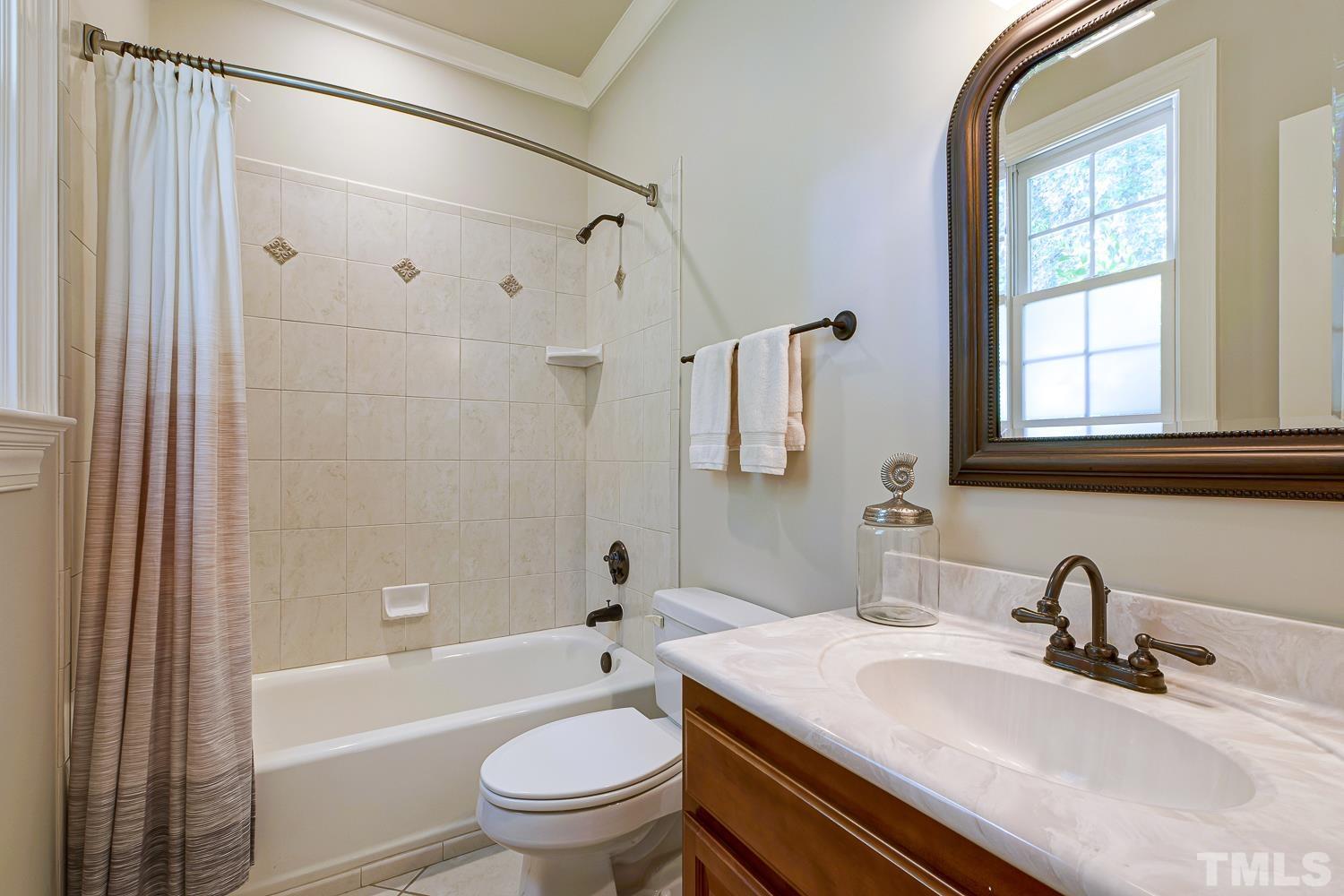 5201 Rathkeale Court Holly Springs, NC 27540 - Photo 23 of 46 a bathroom with a sink toilet tub and shower