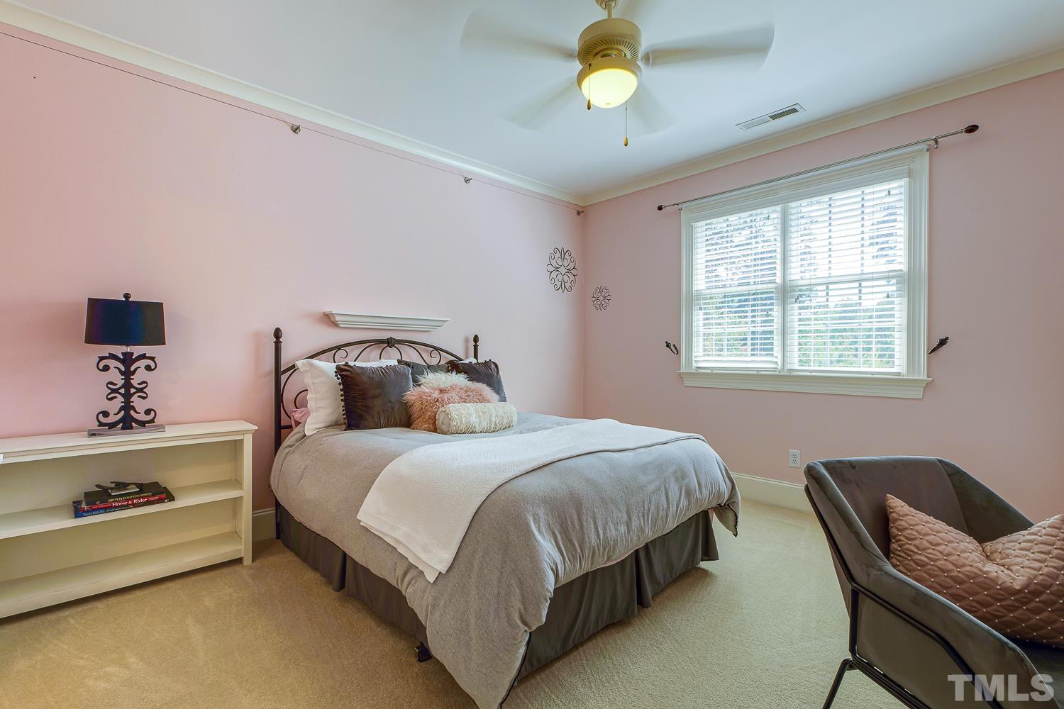 5201 Rathkeale Court Holly Springs, NC 27540 - Photo 25 of 46 a bedroom with a bed and a chandelier