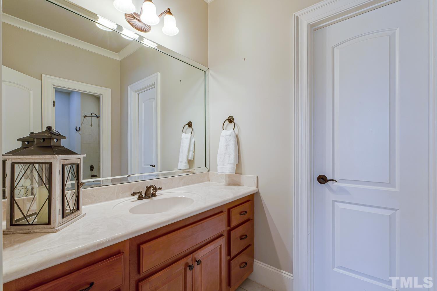 5201 Rathkeale Court Holly Springs, NC 27540 - Photo 26 of 46 a bathroom with a sink vanity granite and a mirror