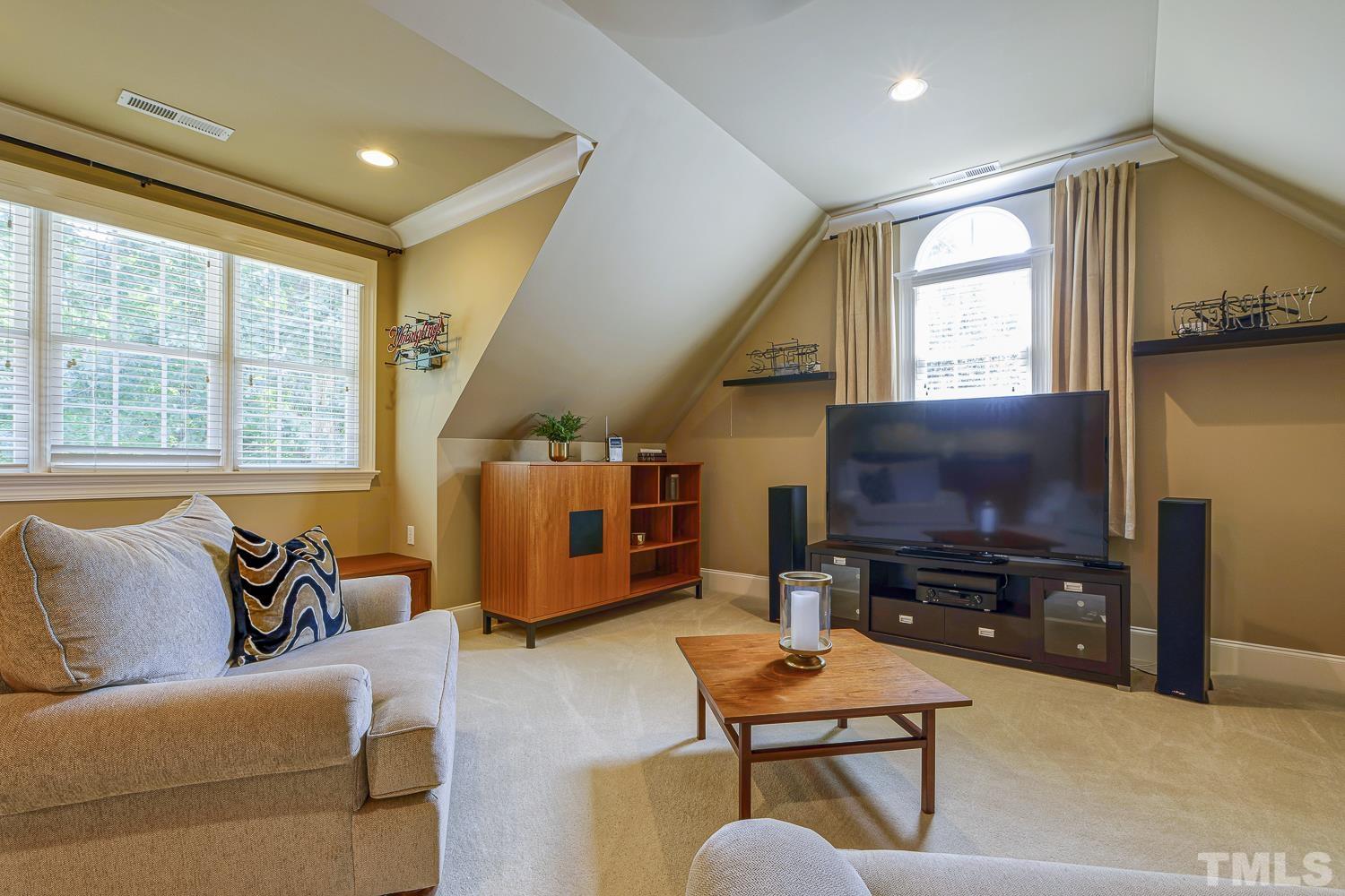 5201 Rathkeale Court Holly Springs, NC 27540 - Photo 28 of 46 a living room with furniture and a flat screen tv
