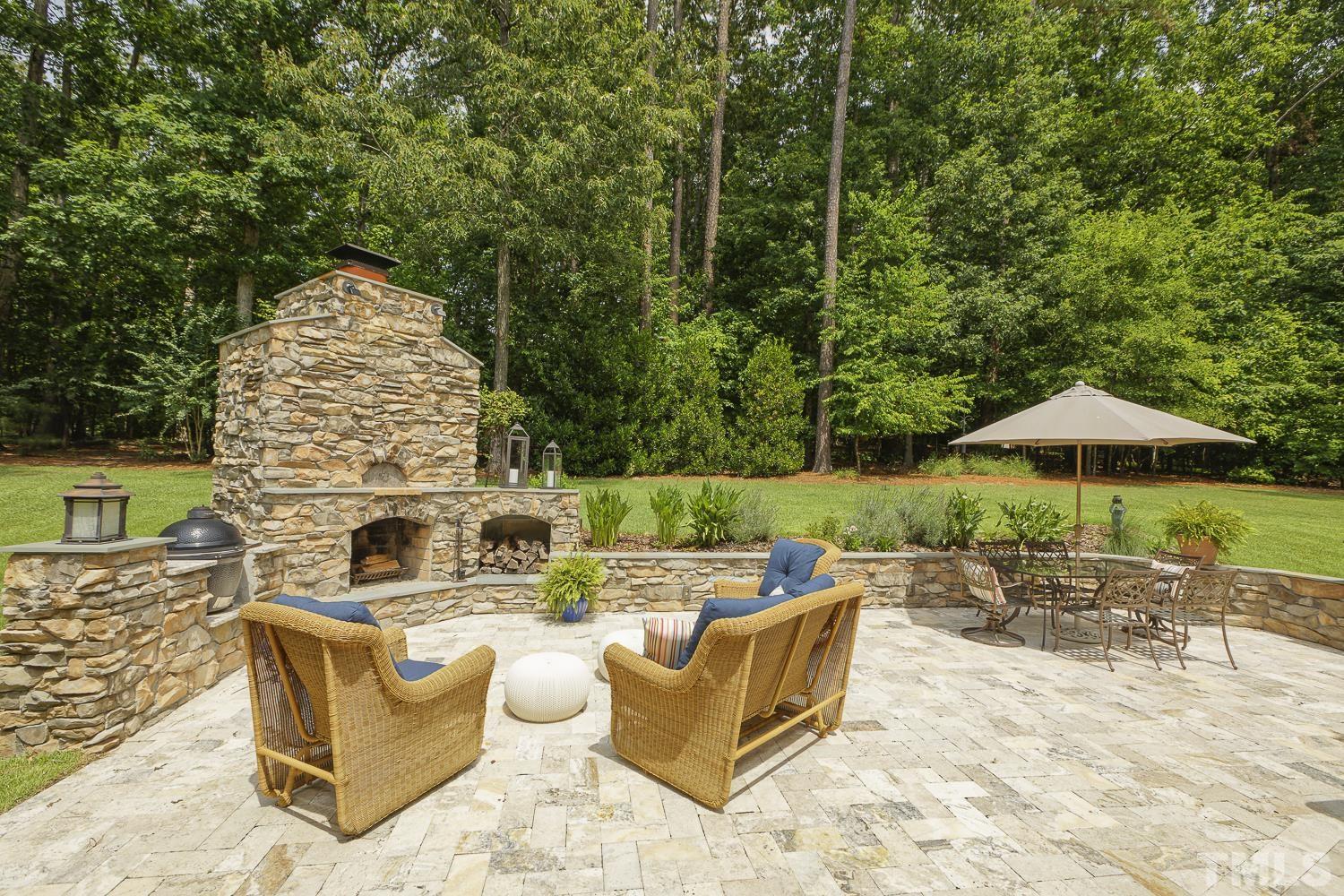 5201 Rathkeale Court Holly Springs, NC 27540 - Photo 36 of 46 an outdoor sitting area with furniture and umbrella
