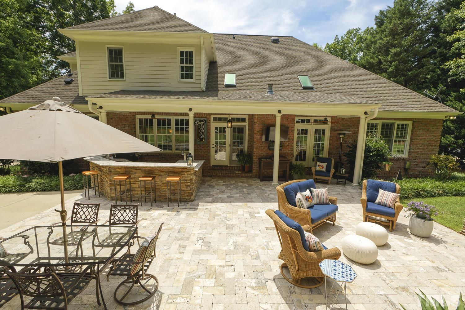 5201 Rathkeale Court Holly Springs, NC 27540 - Photo 41 of 46 a view of a patio with table and chairs potted plants and a barbeque