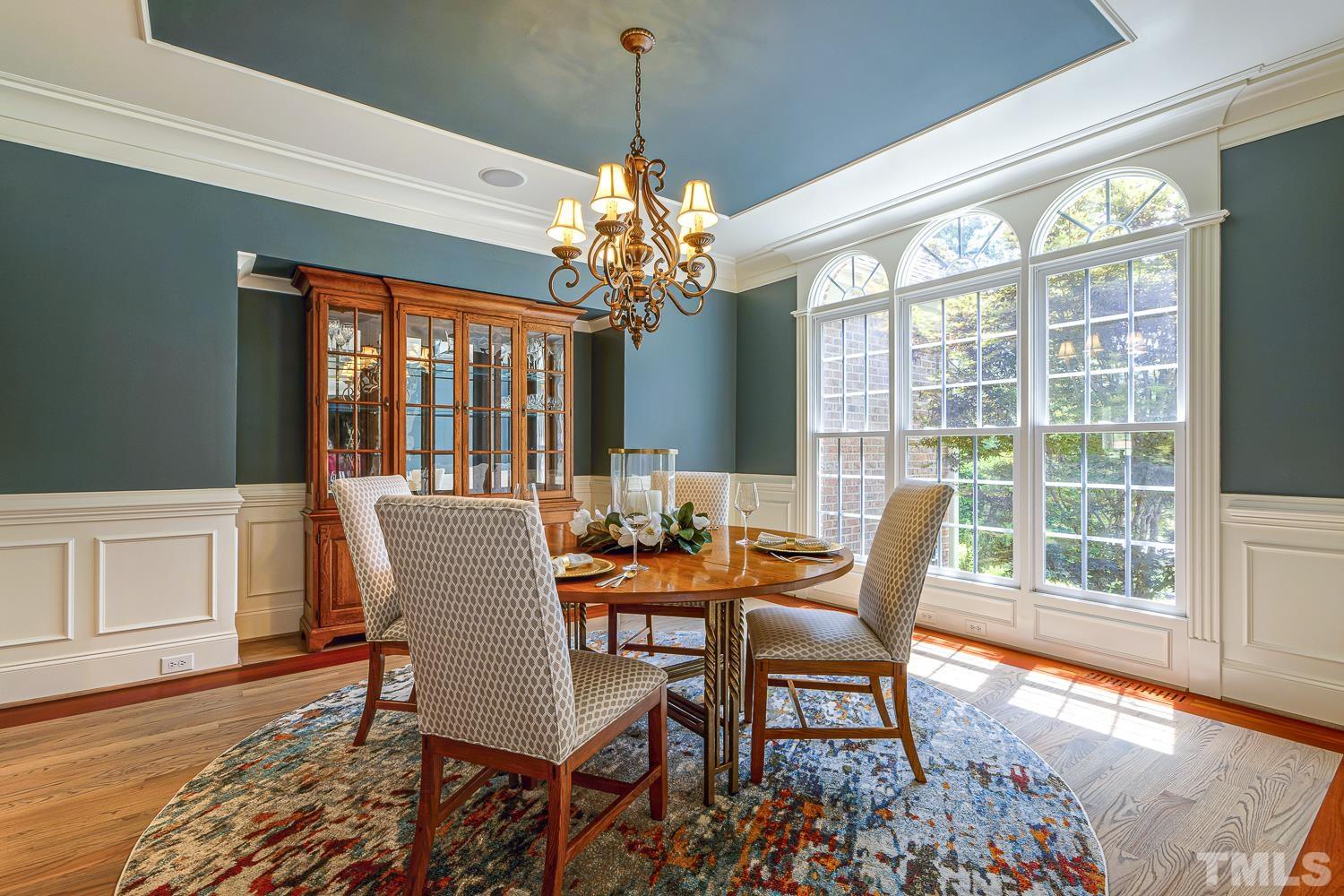 5201 Rathkeale Court Holly Springs, NC 27540 - Photo 6 of 46 a dining room with wooden floor a chandelier a glass table and chairs