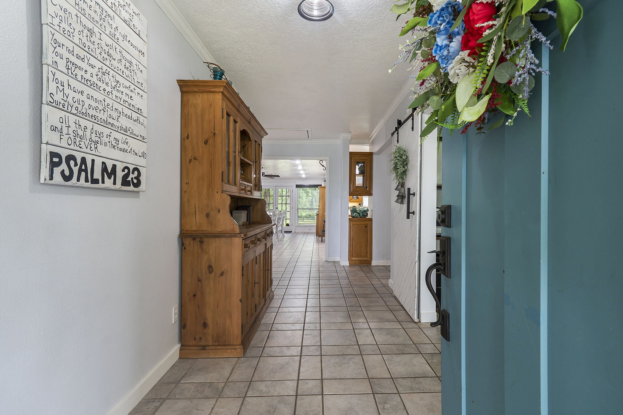 7363 County Line Road Willis, TX 77378 - Photo 3 of 34 Welcome home to a charming entrance featuring a vibrant door, elegant tile flooring, and warm wood accents, setting the tone for a cozy and inviting interior.