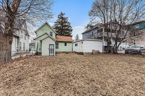 a yellow house with a yard and parking space
