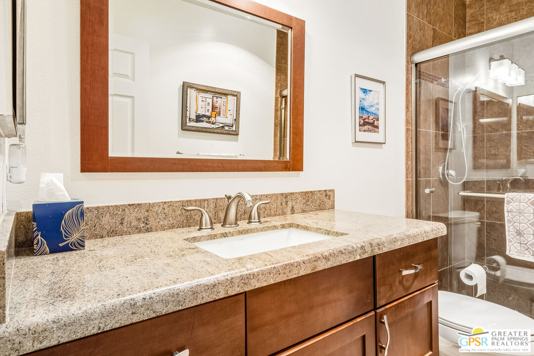 1103 East Alejo Road Palm Springs, CA 92262 - Photo 26 of 39 a bathroom with a granite countertop sink and a mirror
