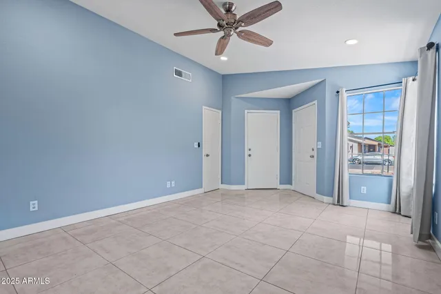 an empty room with closet and a ceiling fan