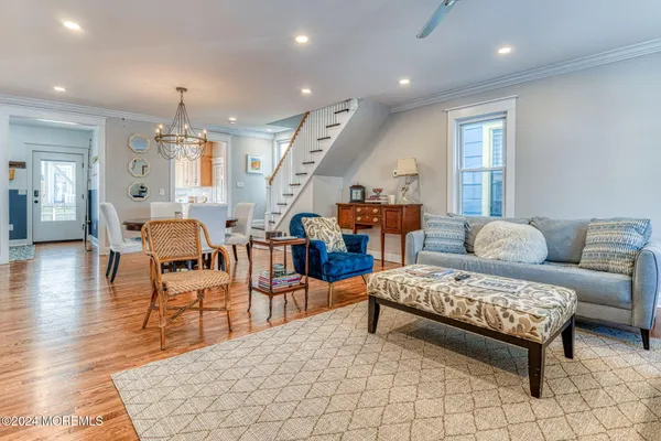 a view of a dining room with furniture a chandelier and wooden floor