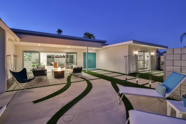 a living room with furniture a rug and white walls
