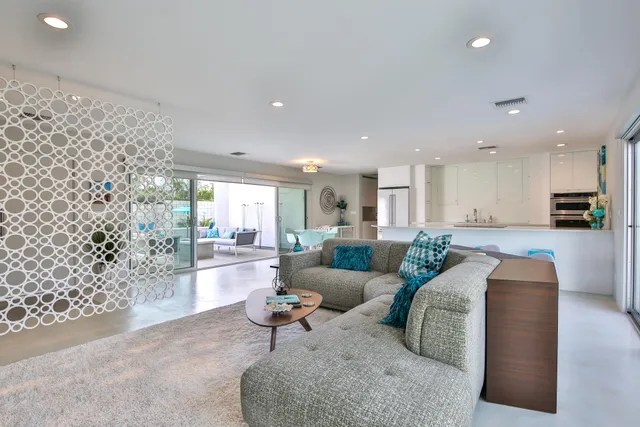 a kitchen with white cabinets and chairs