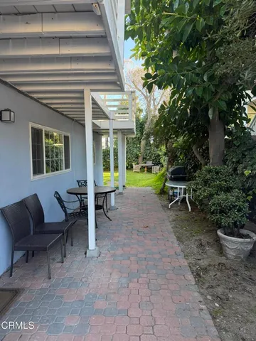 a view of a house with backyard and sitting area