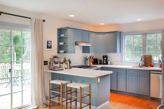 a kitchen that has a sink a stove counter top space and cabinets
