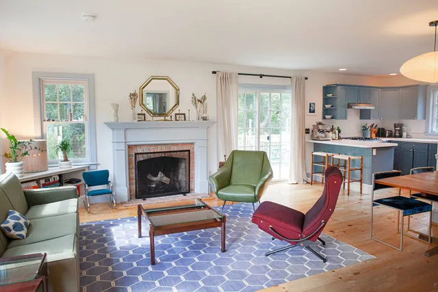 a living room with furniture a rug and a fireplace