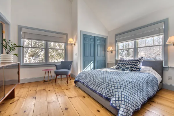 a bedroom with a bed and a large window