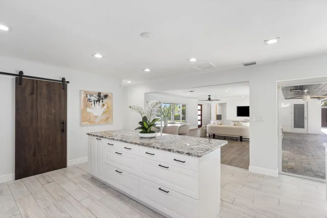 a kitchen with stainless steel appliances kitchen island granite countertop a refrigerator and microwave