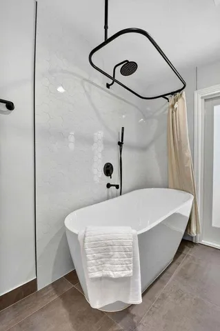 an empty room with wooden floor chandelier fan and windows