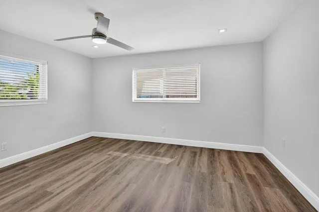 a view of a backyard with wooden fence and large trees
