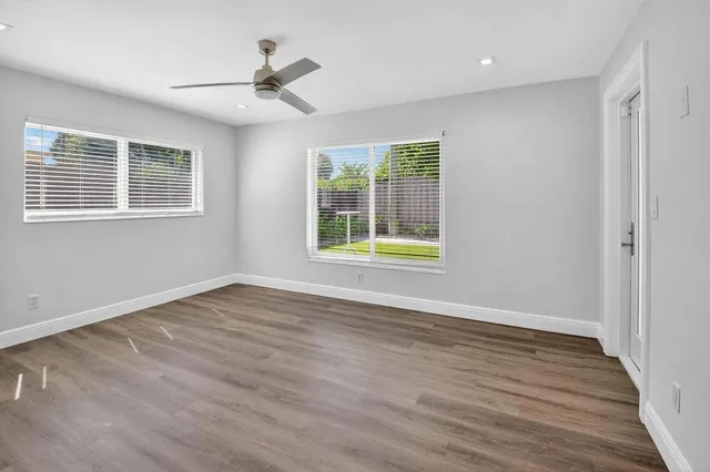 a front view of a house with a yard and potted plants