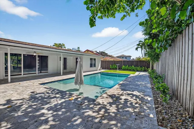 a view of backyard with a garden and palm trees