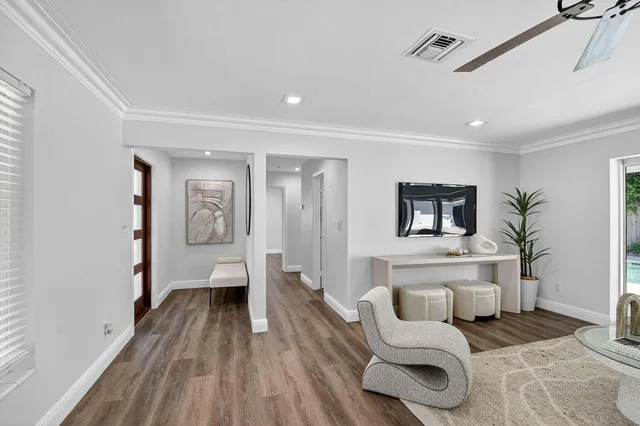 a living room with furniture a flat screen tv and a large window