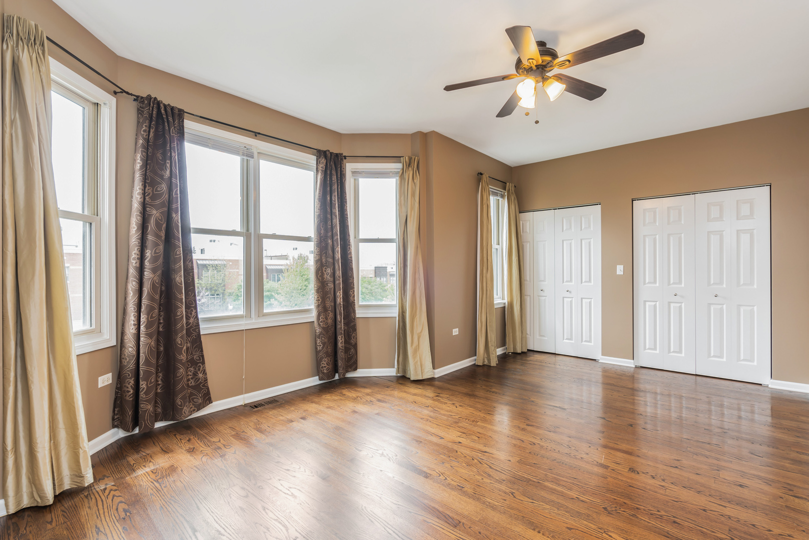 721 West 15th Street Chicago, IL 60607 - Photo 18 of 27 an empty room with wooden floor and windows with curtains