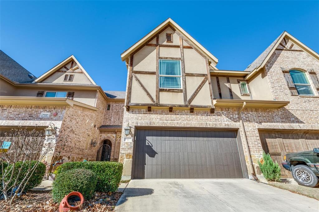 a view of a house with a yard and potted plants