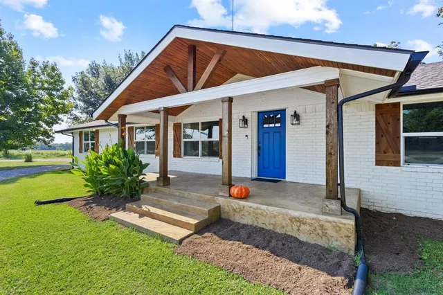 a view of a house with porch and garden