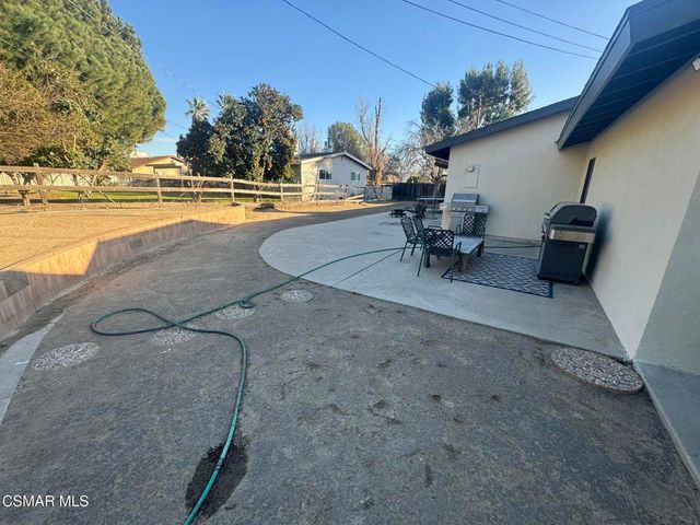 a view of a swimming pool with outdoor seating and yard in the back